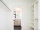 Well-organized walk-in closet leading to bathroom, with open shelving and sleek black tile flooring at 263 S Jackson St, Denver, CO 80209