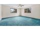 Bright bedroom with neutral walls, teal carpet and natural light from two windows at 15623 Degaulle Cir, Brighton, CO 80603