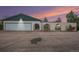 A home with a large garage and interesting privacy wall and arched entry at dusk at 15623 Degaulle Cir, Brighton, CO 80603