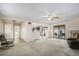 Spacious carpeted living room with ceiling fan, adjacent kitchen and fireplace at 15623 Degaulle Cir, Brighton, CO 80603