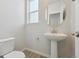 Powder room with pedestal sink, toilet and light gray walls at 25022 E 34Th Pl, Aurora, CO 80019