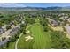 Beautiful aerial view of a golf course community with mature trees and mountain views in the background at 7081 Salvia St, Arvada, CO 80007