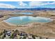 Scenic aerial view capturing a serene lake landscape with clear blue waters and a home nearby at 7081 Salvia St, Arvada, CO 80007