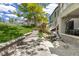 Inviting backyard featuring a charming rock waterfall, stone patio, and a well-maintained lawn at 7081 Salvia St, Arvada, CO 80007