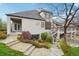 A home's backyard featuring a covered patio, upper deck, mature trees, and lush landscaping at 7081 Salvia St, Arvada, CO 80007
