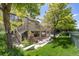 Multi-tiered backyard featuring a deck, patio, lush lawn, and mature trees at 7081 Salvia St, Arvada, CO 80007