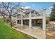 A home's backyard with a patio, upper deck, mature trees, and beautiful landscaping at 7081 Salvia St, Arvada, CO 80007