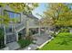Multi-level backyard featuring a stone patio, elevated deck, and lush landscaping creating a serene retreat at 7081 Salvia St, Arvada, CO 80007