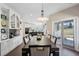 Open dining area with sleek white cabinetry, modern lighting, and seamless flow to the kitchen at 7081 Salvia St, Arvada, CO 80007