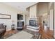Open-concept living room with a statement fireplace, hardwood floors, and a convenient wet bar for entertaining at 7081 Salvia St, Arvada, CO 80007