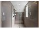 Shower stall featuring gray tile and a shower seat at 7081 Salvia St, Arvada, CO 80007