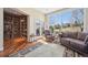 Cozy sunroom with large windows, hardwood floors, and an adjacent bookshelf-lined room at 7081 Salvia St, Arvada, CO 80007