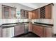 Basement wet bar with granite countertops, stainless steel appliances, and dark wood cabinetry at 7081 Salvia St, Arvada, CO 80007
