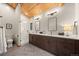 Bright bathroom featuring double sink vanity, wood ceiling and herringbone floors at 80 Spruce Ct, Evergreen, CO 80439