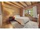Cozy bedroom features wood-paneled walls, plush rug, and view of the outdoors from the window at 80 Spruce Ct, Evergreen, CO 80439