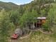 Secluded mountain home surrounded by trees, featuring a deck and solar panels at 80 Spruce Ct, Evergreen, CO 80439