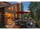 Inviting outdoor patio with stone fireplace, seating, and forest views creates a perfect spot for relaxation at 80 Spruce Ct, Evergreen, CO 80439