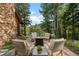 Charming stone patio with fire pit, comfortable seating, and natural surroundings for relaxation at 80 Spruce Ct, Evergreen, CO 80439