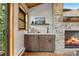 Rustic wet bar featuring stone fireplace, dark wood cabinets, and a picturesque mountain view at 80 Spruce Ct, Evergreen, CO 80439