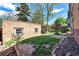 Backyard with green grass, brick building, wooden fence, and trees at 766 Monroe St, Denver, CO 80206
