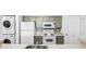 Efficient kitchen design with stackable washer/dryer, white appliances, and gray cabinets at 4899 S Dudley St # 7E, Littleton, CO 80123
