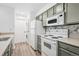 Functional kitchen with stackable washer/dryer, updated appliances, and gray cabinets at 4899 S Dudley St # 7E, Littleton, CO 80123