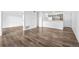 Open-concept living area with wood-look floors connecting to a kitchen with modern appliances and a breakfast bar at 4899 S Dudley St # 7E, Littleton, CO 80123
