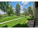 Expansive lawn with mature trees, a paved walkway, and a bright blue sky with fluffy clouds above at 4899 S Dudley St # 7E, Littleton, CO 80123