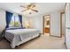 Bright bedroom featuring a ceiling fan, blue curtains, and ensuite bathroom at 9655 W 105Th Way, Broomfield, CO 80021