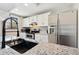 Bright kitchen featuring stainless steel appliances, white cabinets, and granite countertops at 9655 W 105Th Way, Broomfield, CO 80021