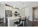 Modern kitchen featuring an island with seating, stainless appliances, white cabinets, and elegant pendant lighting at 22210 E Mansfield Pl, Aurora, CO 80018