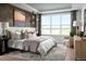 Sun-filled main bedroom with a large window, wood accent wall, and comfortable furnishings at 5726 Margarita Pt, Parker, CO 80134