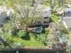 An aerial view showcasing the home's backyard with lush lawn, a deck, storage shed, and mature trees at 128 Baylor Dr, Longmont, CO 80503