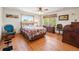 Comfortable bedroom with hardwood floors, a ceiling fan, and a large window offering natural light at 128 Baylor Dr, Longmont, CO 80503