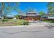 Charming home featuring a three-car garage and a lush green lawn with mature trees at 128 Baylor Dr, Longmont, CO 80503