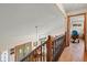 Bright hallway featuring wood floors, wood railing, and an open view of the home's entry at 128 Baylor Dr, Longmont, CO 80503