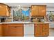 Well-lit kitchen featuring wood cabinets, white appliances, and a bright window above the sink at 128 Baylor Dr, Longmont, CO 80503
