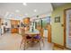 Eat-in kitchen featuring wood cabinets, tile flooring, and a bright window overlooking the backyard at 128 Baylor Dr, Longmont, CO 80503
