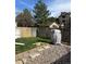 Backyard featuring a covered grill, grass, stepping stones, gravel area, and a wood fence at 9610 W Chatfield Ave # F, Littleton, CO 80128
