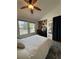 Bright bedroom with a ceiling fan, closet shelving, and a window view of the neighborhood at 9610 W Chatfield Ave # F, Littleton, CO 80128