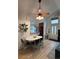 Dining area with modern lighting, clear chairs, and access to the kitchen and front entrance at 9610 W Chatfield Ave # F, Littleton, CO 80128