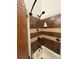 Shower featuring decorative brown tiling and a modern bronze shower head fixture at 9610 W Chatfield Ave # F, Littleton, CO 80128