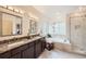 Elegant bathroom with granite counters, dual sinks, soaking tub, and tiled glass shower at 176 S Rosemary St, Denver, CO 80230