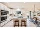 Bright kitchen with white cabinets, stainless steel appliances, a center island, and an adjacent dining area at 176 S Rosemary St, Denver, CO 80230