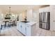 Open-concept kitchen with stainless steel appliances, an island cooktop, and an adjacent dining area at 176 S Rosemary St, Denver, CO 80230