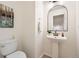 Clean powder room with a pedestal sink, toilet, and decorative artwork at 176 S Rosemary St, Denver, CO 80230