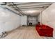 Unfinished basement features painted floor and walls, exposed ceiling, and red sofa at 39167 Braxton Ln, Elizabeth, CO 80107