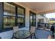 Covered porch features windows and sliding door, with a dining table and chairs at 39167 Braxton Ln, Elizabeth, CO 80107