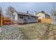 Exterior view of home and backyard featuring green grass and a wooden fence at 4542 S Quintero St, Aurora, CO 80015