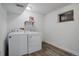 Laundry room with wood-look flooring, a window, overhead lighting, washer, and dryer at 4542 S Quintero St, Aurora, CO 80015